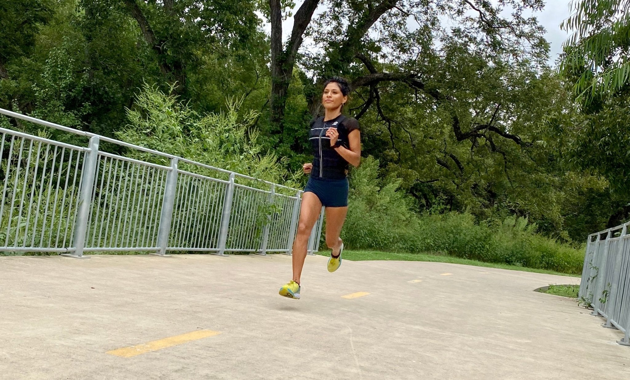 Picture of a person running with a weighted vest on a trail