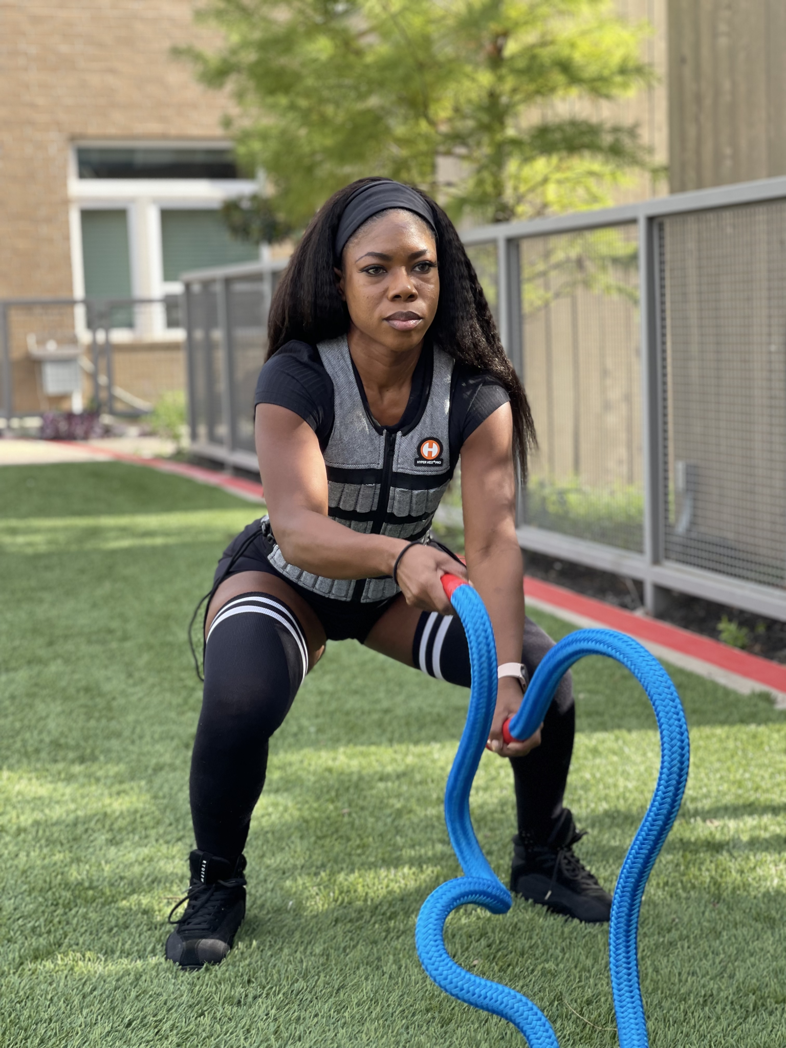 image of female fitness model in squat position doing waves with heavy jump rope