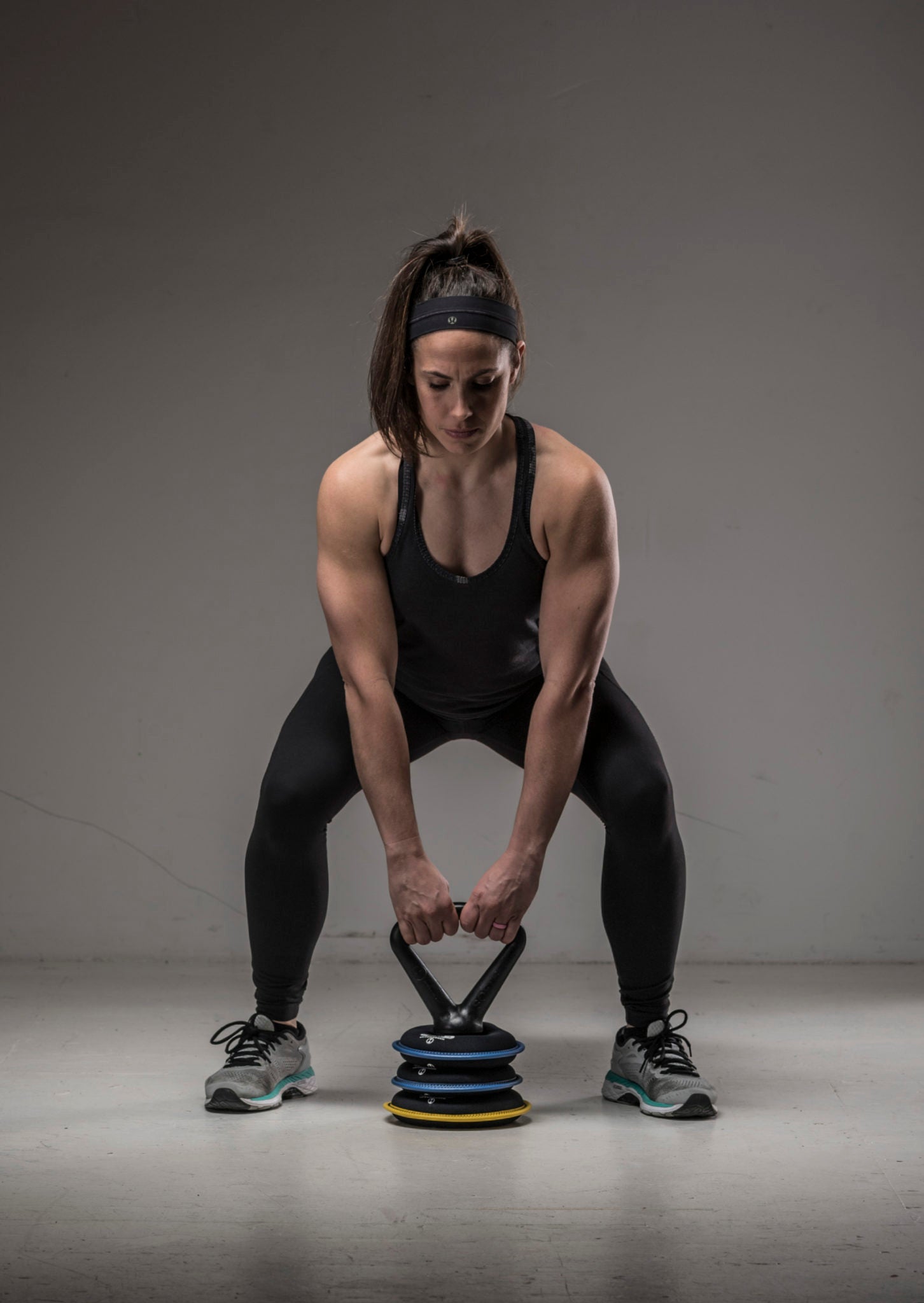 image of strong female model holding the SoftBell adjustable soft kettlebell preparing to do a kettlebell deadlift