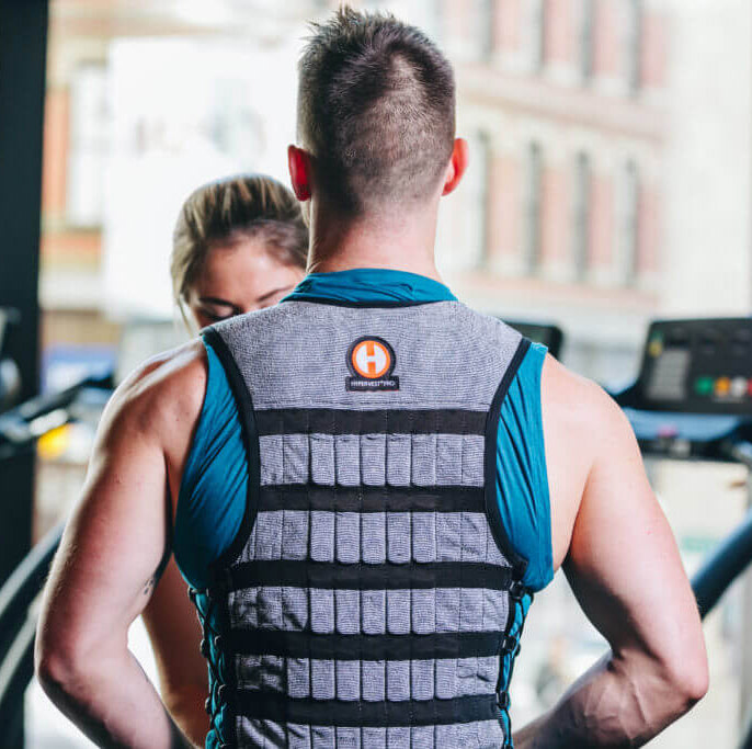 image of back of male model wearing the thin hyper vest pro weight vest with many small removable weights visibile