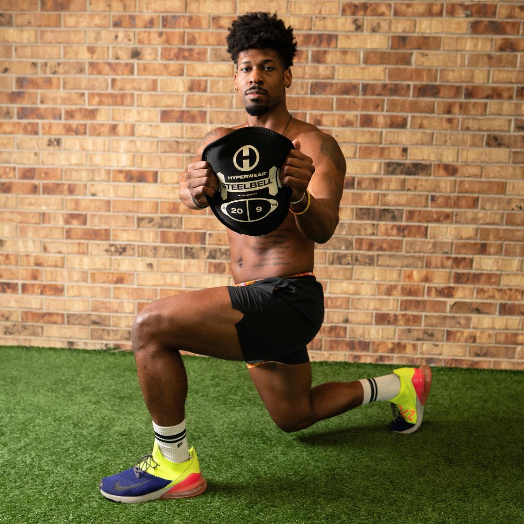 picture of an athlete doing a forward lunge exercise while holding a 50 lb steelbell