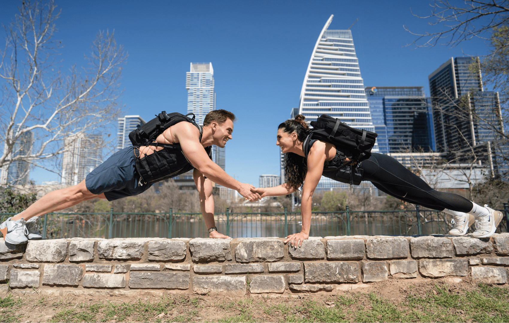 a fit couple doing loaded planks while wearing their Hyper Ruck rucking backpacks