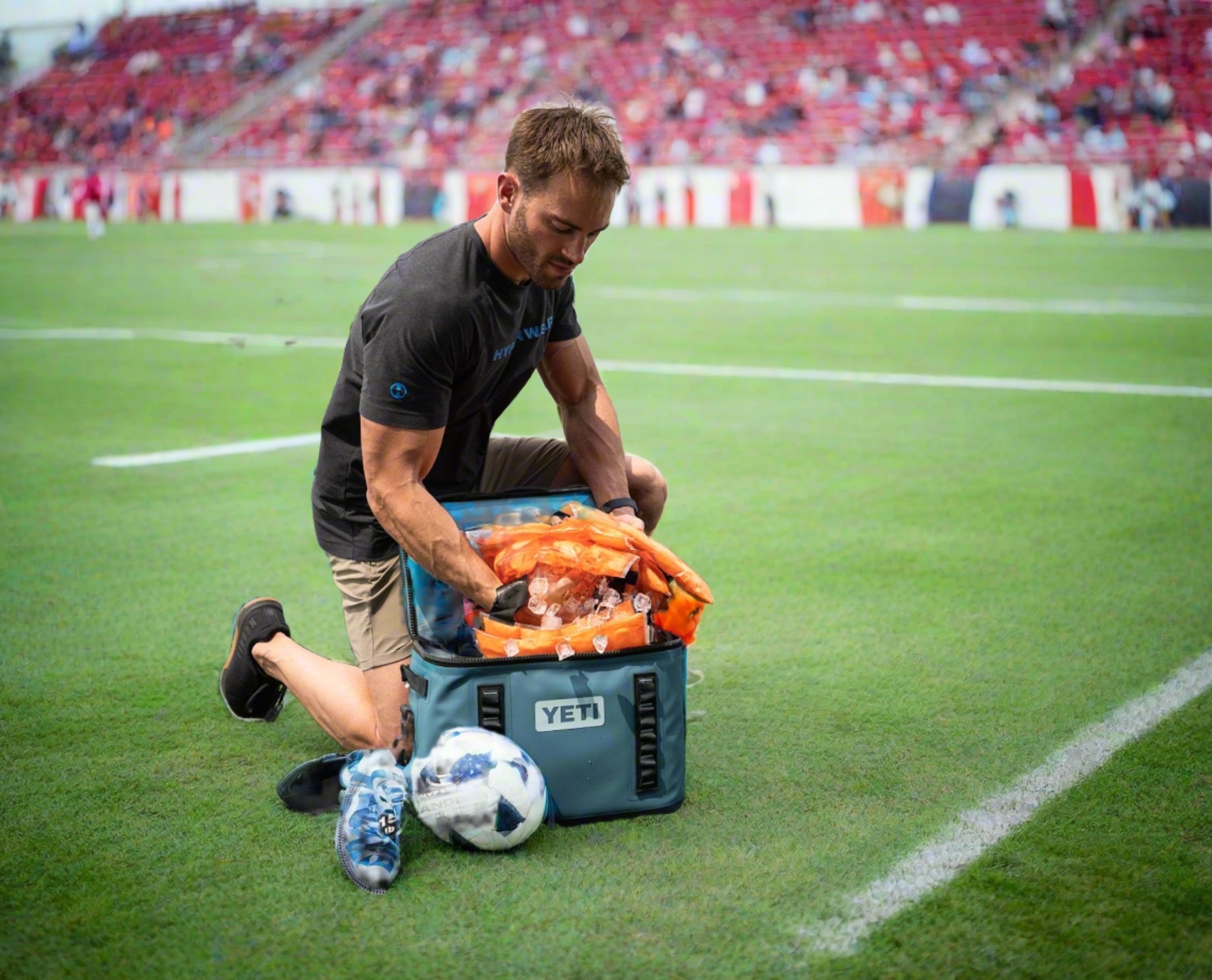 image of a trainer on the sidelines taking cooling vests out of a cooler