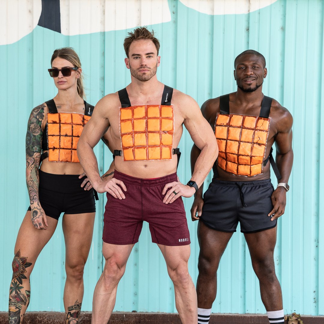 image of three fitness models wearing orange CoolOver cooling vests in an outdoor gym space