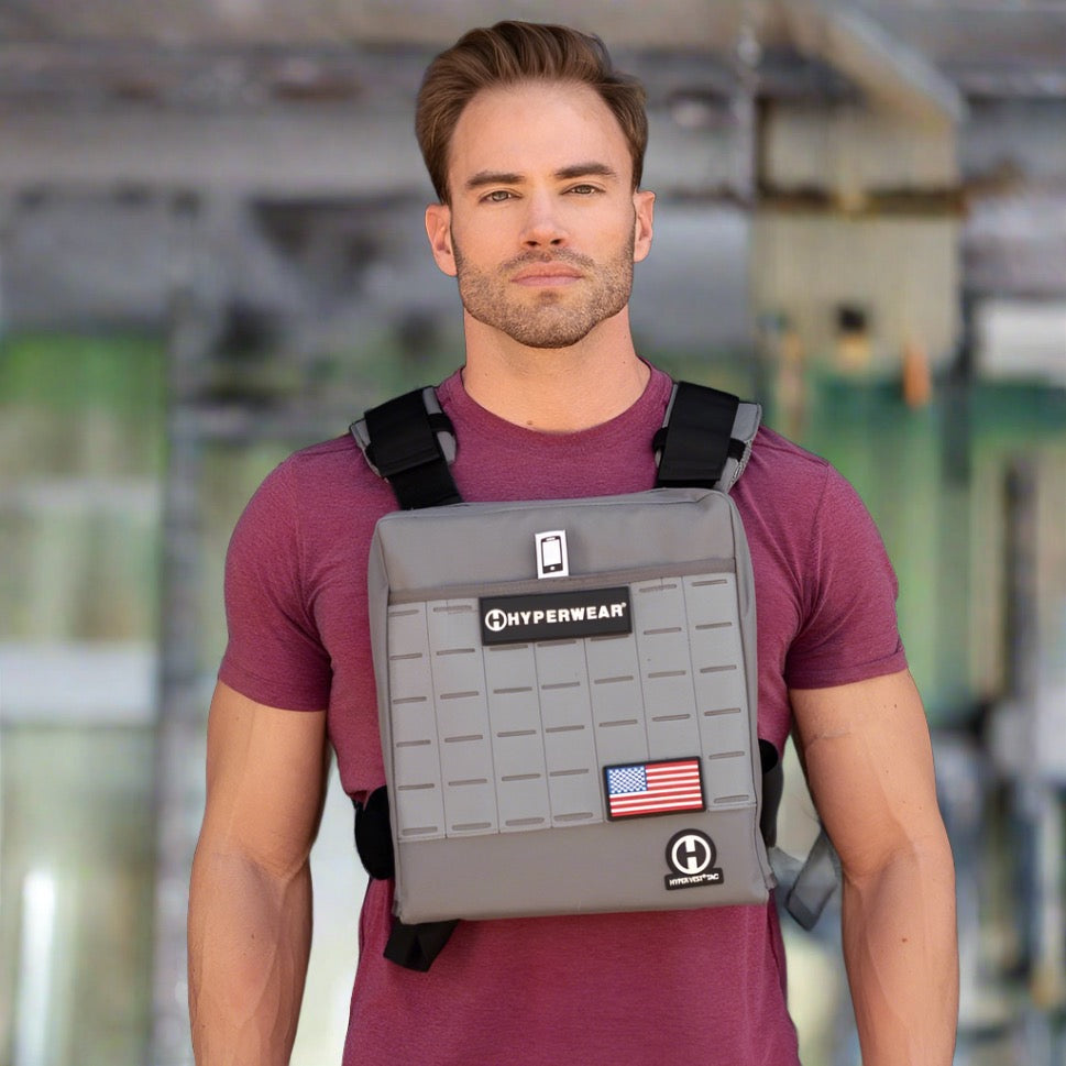 Picture of a male CrossFit athlete standing in a CrossFit box wearing a heavy weight vest