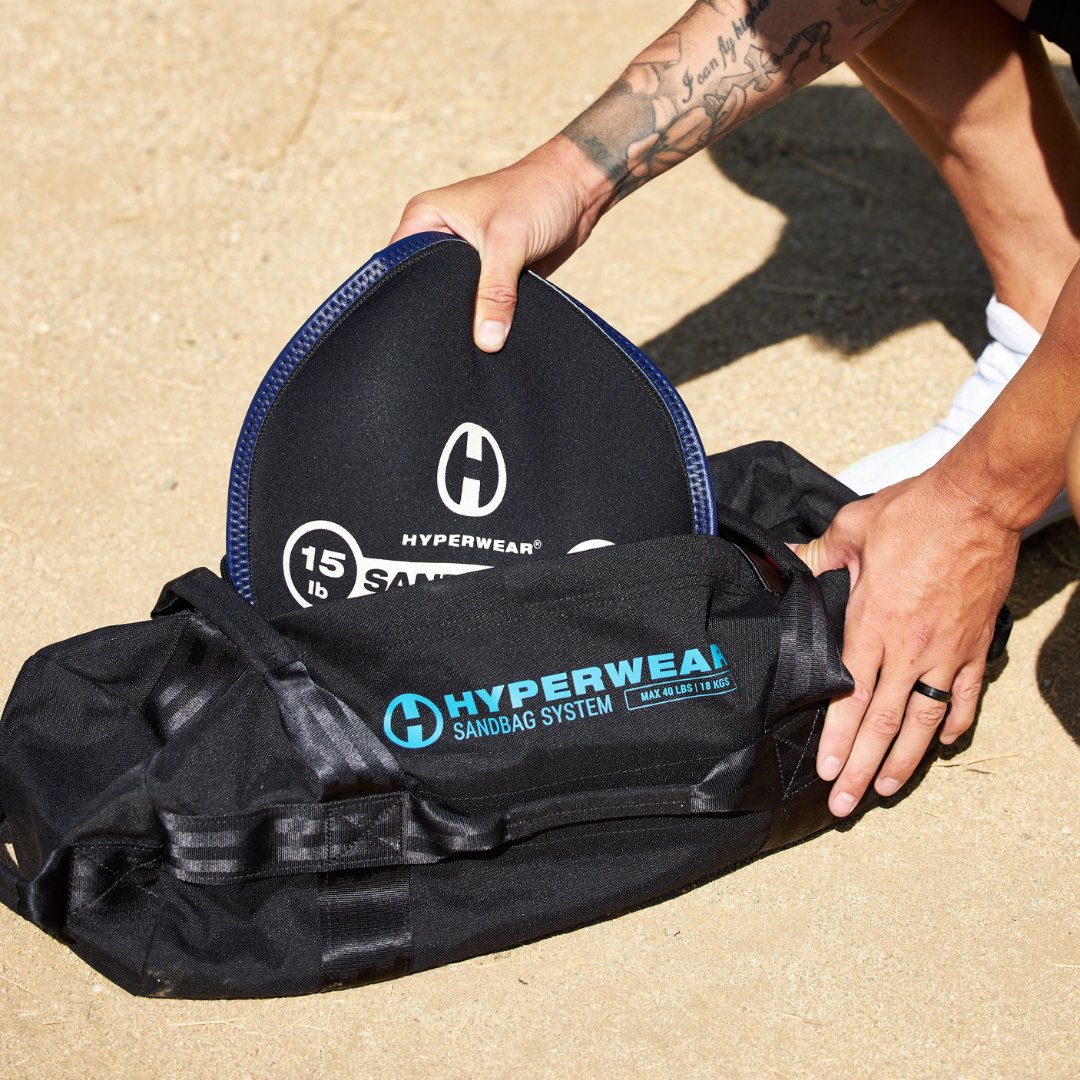 Close up picture of a sandbell being inserted into a handled workout sandbag