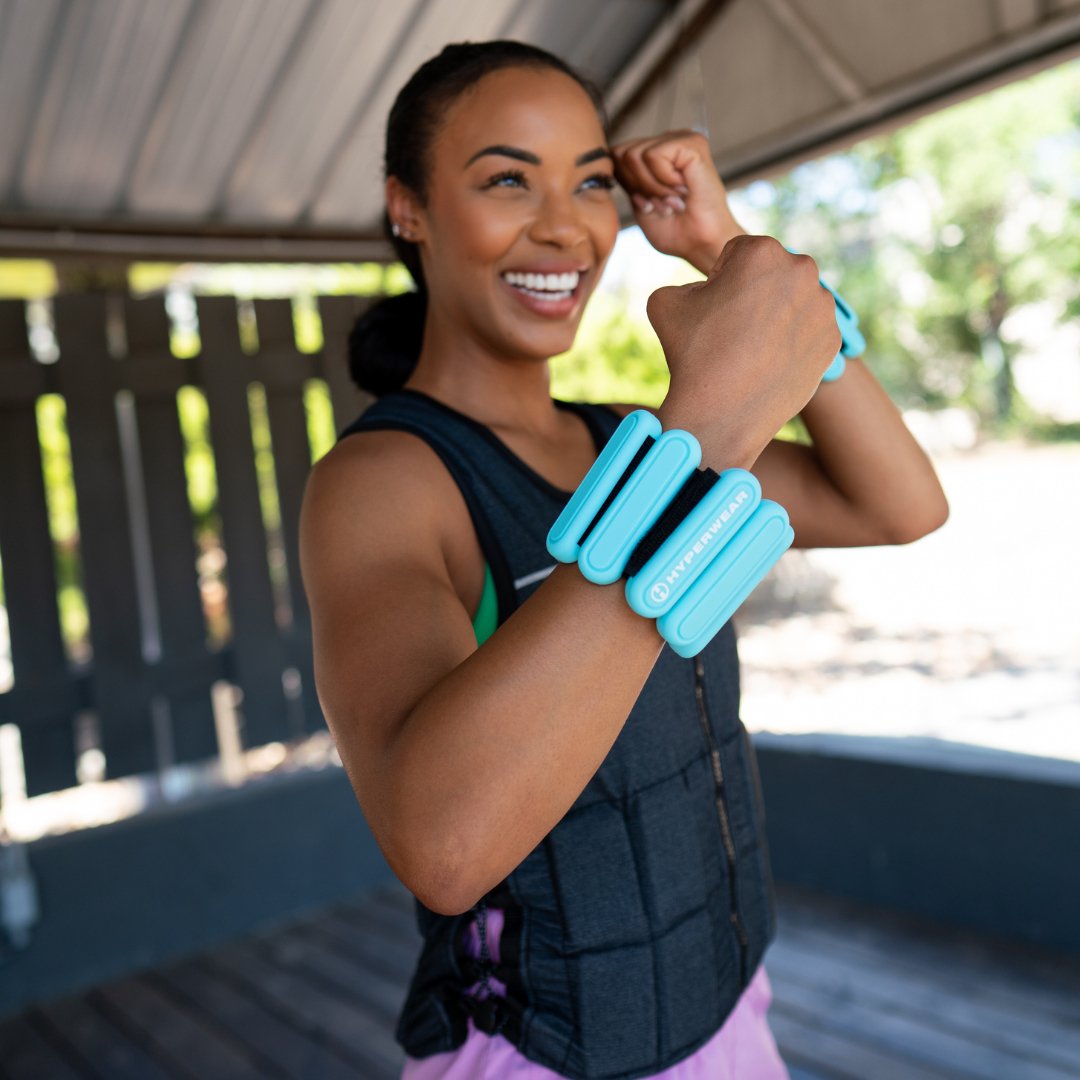 image of a smiling fitness model wearing a hyper vest weight vest and hyperwear wrist weights while working out