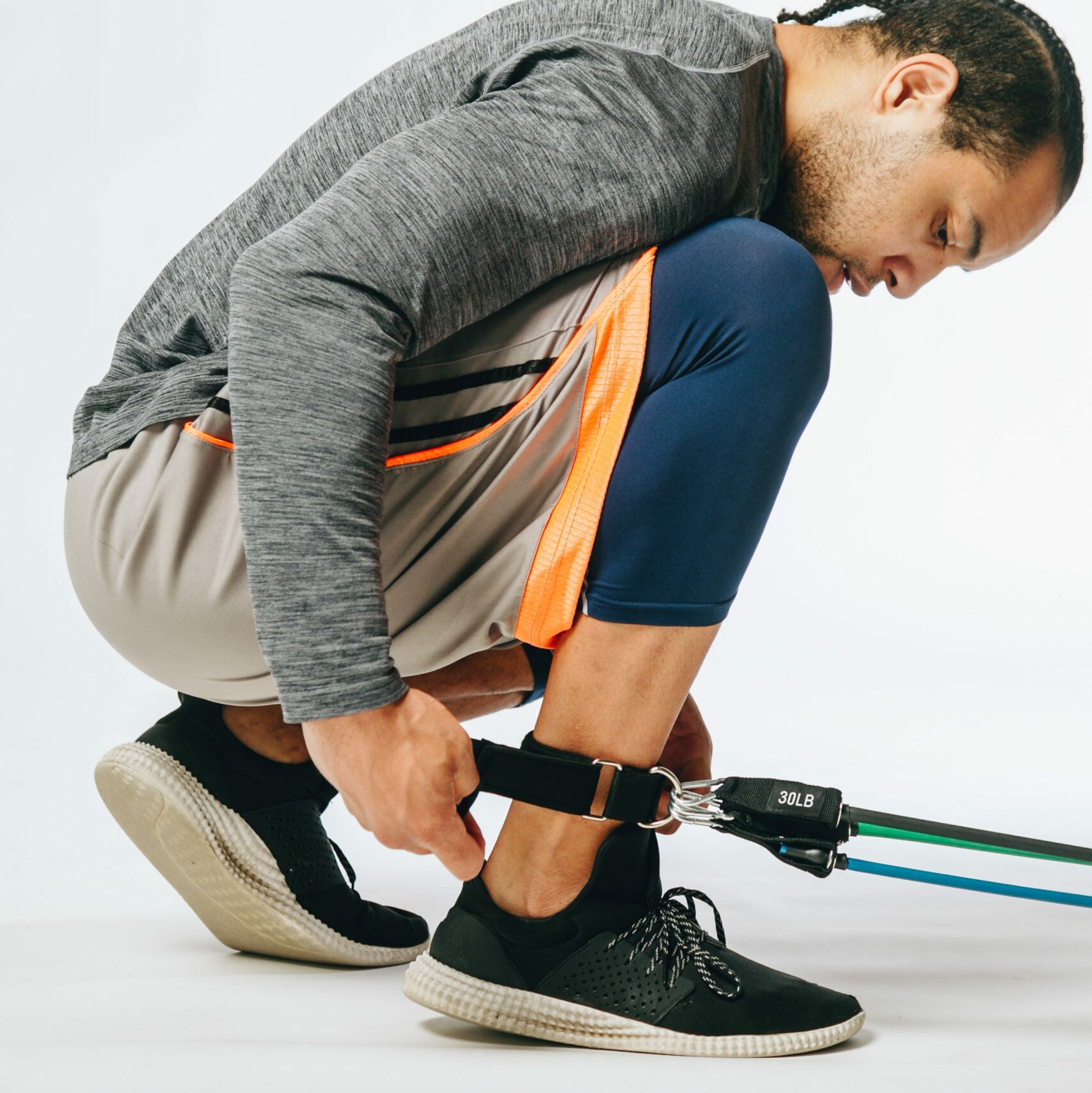 picture of a model attaching resistance tubes to his ankle