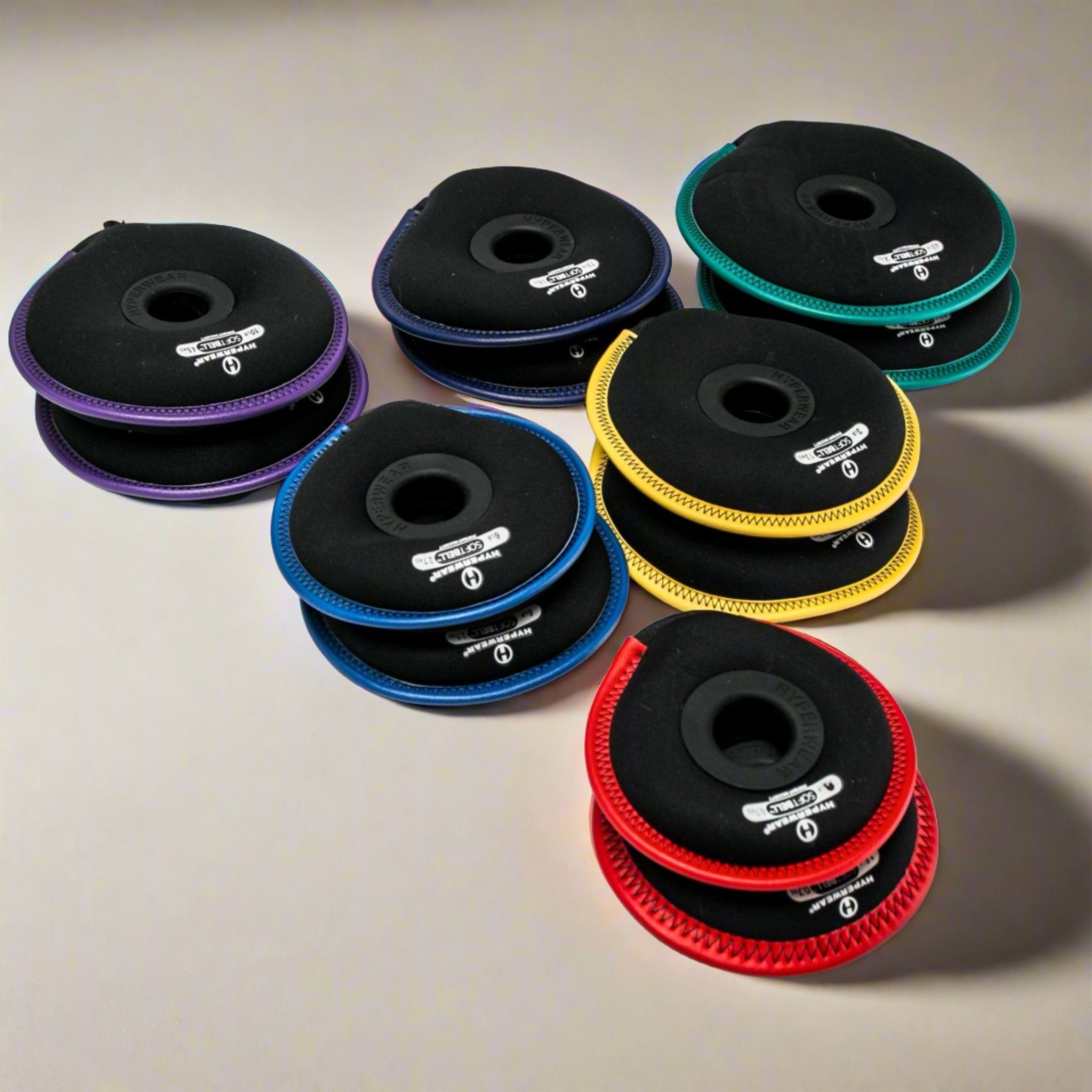 Group product image of an assortment of SoftBell hand weight plates arranged in pairs by color