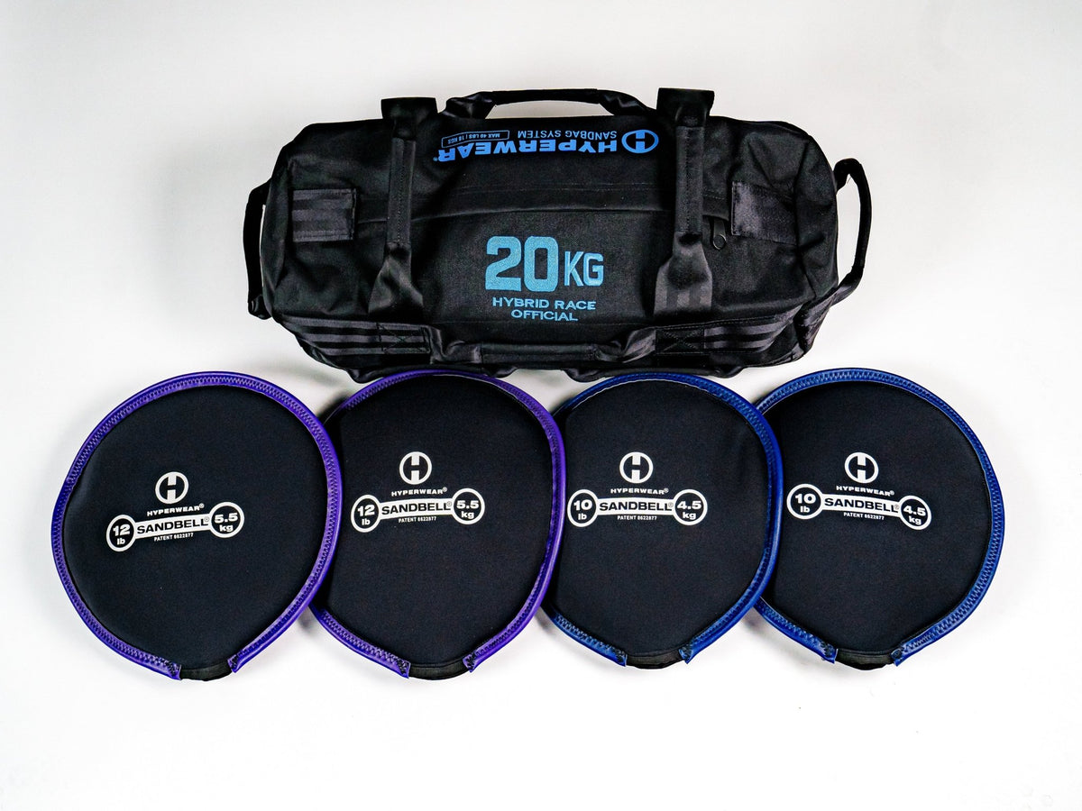 Hyperwear Hybrid Race Training Sandbags in 10, 20 and 30 kg sizes on gym turf, with removable SandBell inserts beside an open bag.