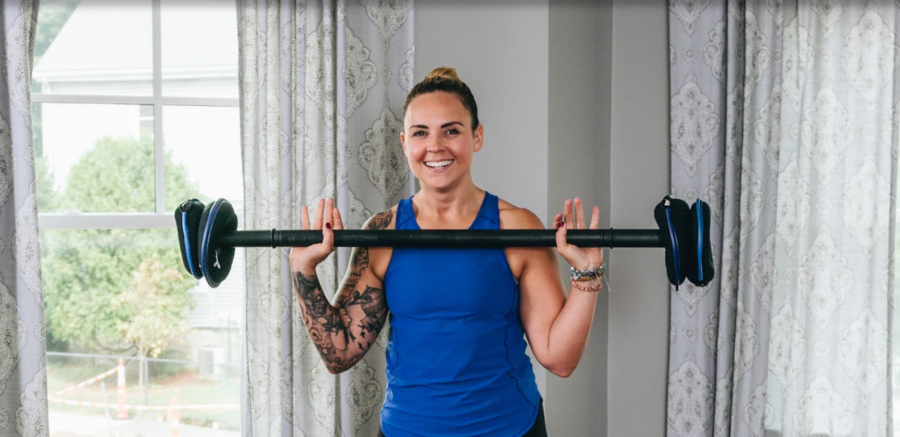 Picture of a woman at home working out with a SoftBell barbell part of the adjustable weight system for home gyms from hyperwear