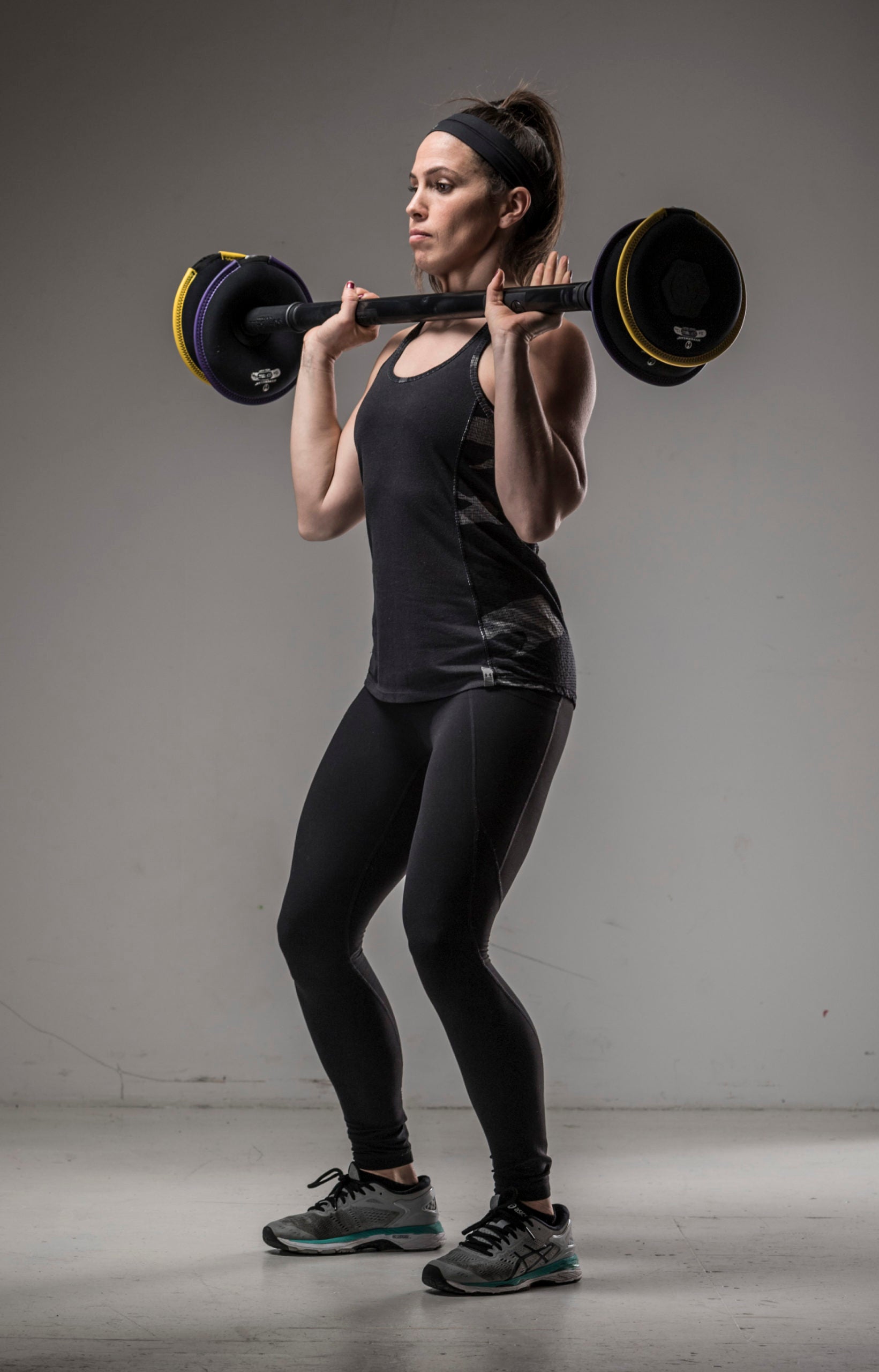 image of female fitness model holding the barbell weight set at 45 lbs in the clean position