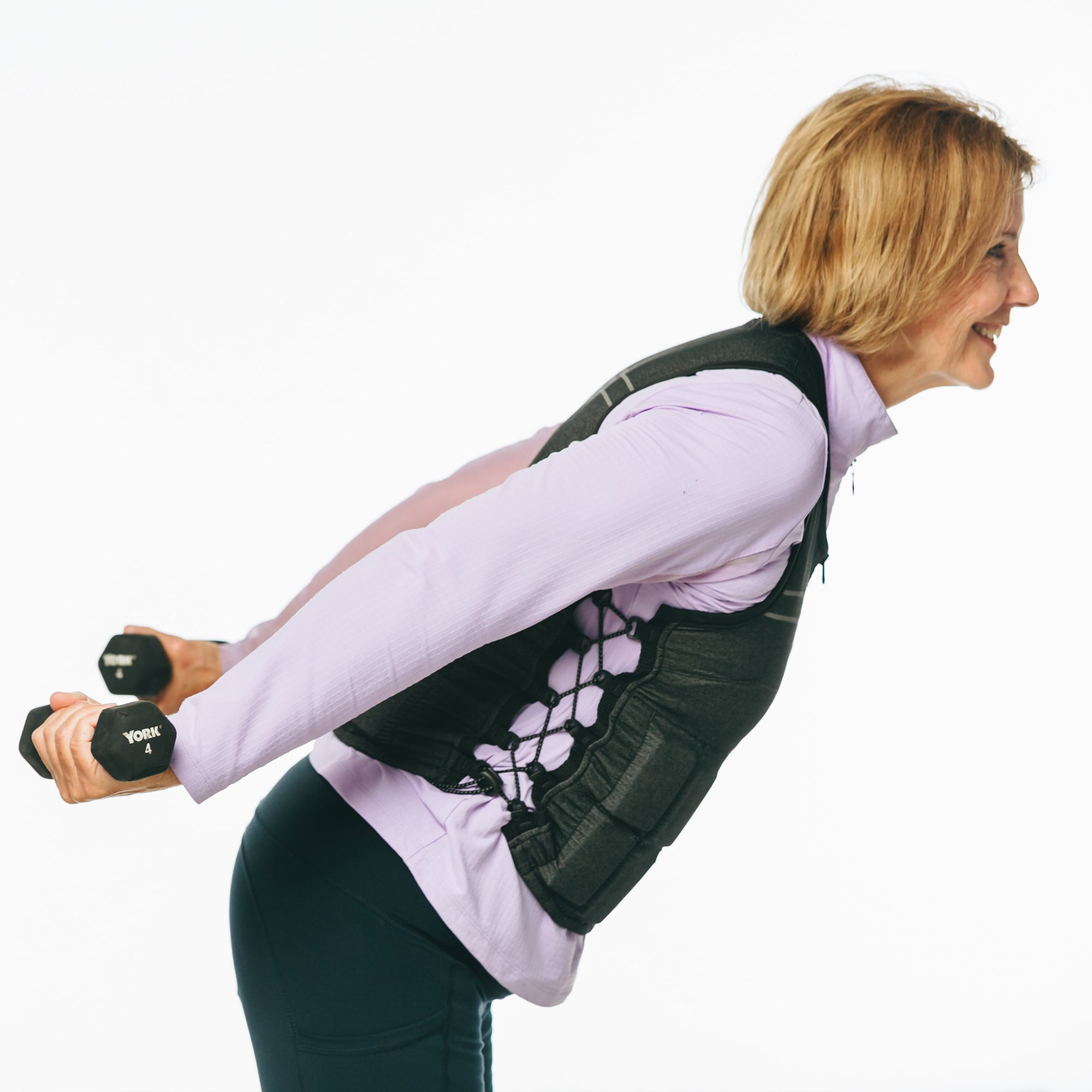 Older female pictured wearing women's weight vest while using dumbbells