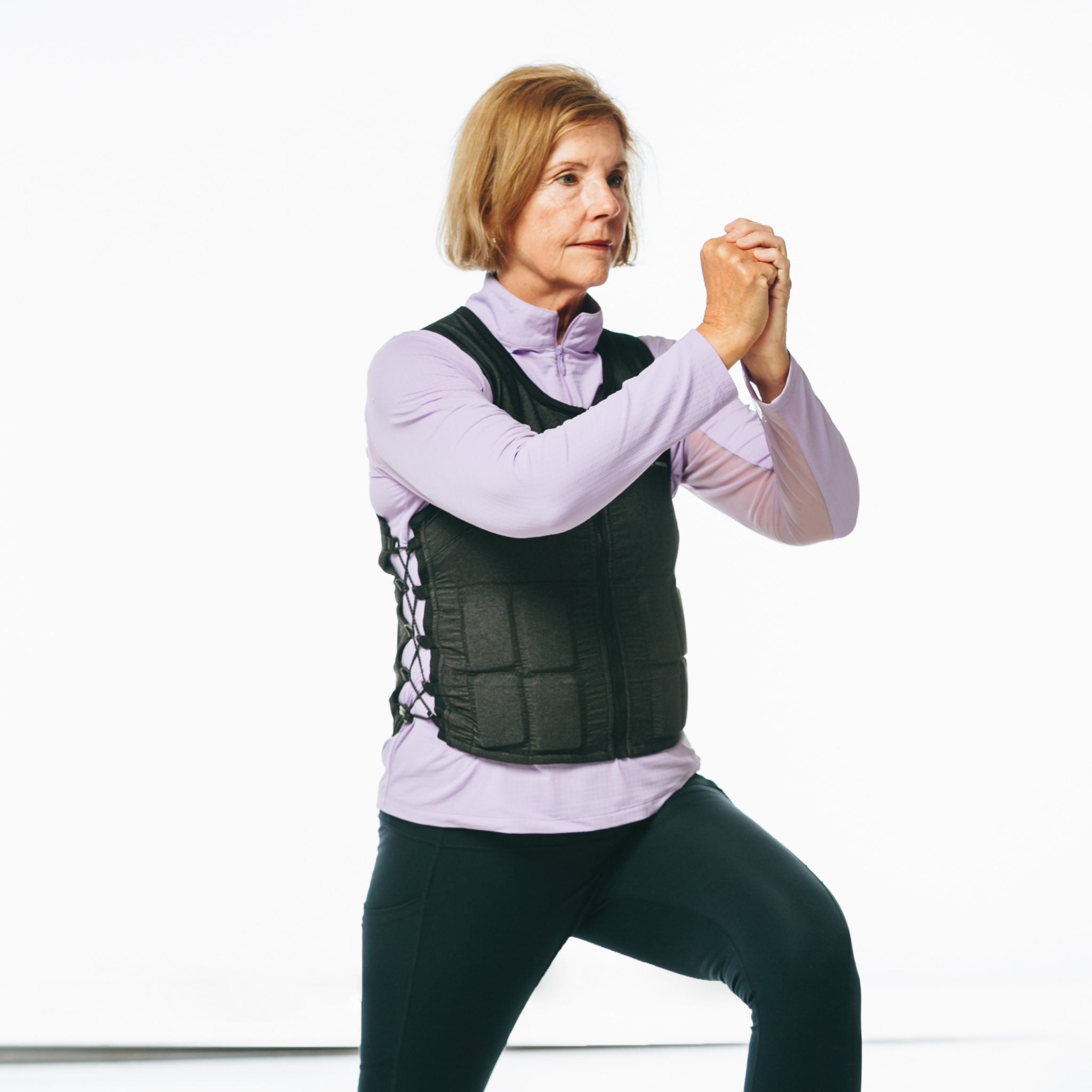 Picture of older woman wearing Hyper Vest FIT weighted vest for women doing a lunge