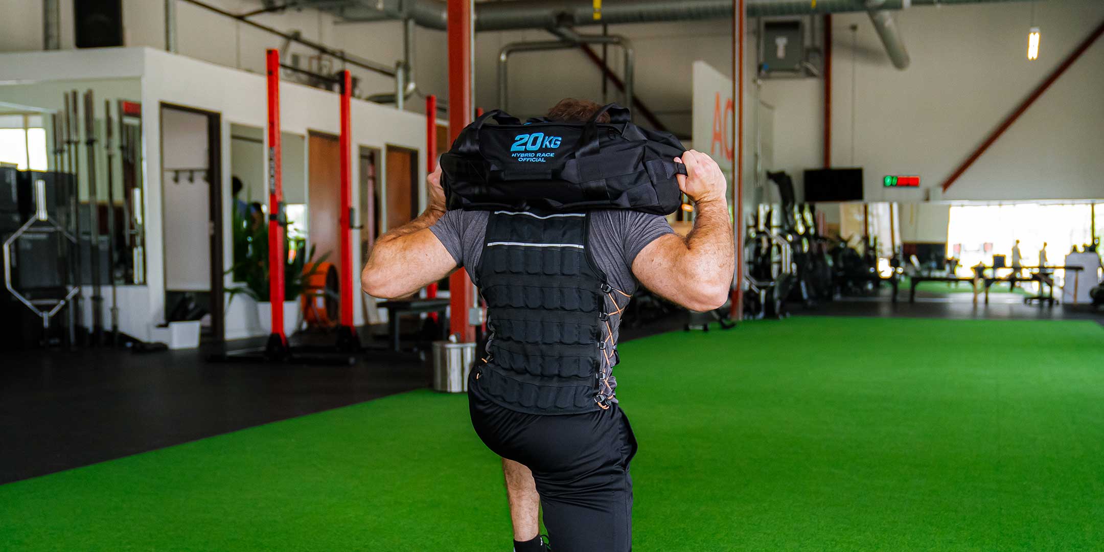 picture of an athlete lunging with a Hyperwear Hybrid Race™ 20KG sandbag training for the Hyrox sandbag lunge