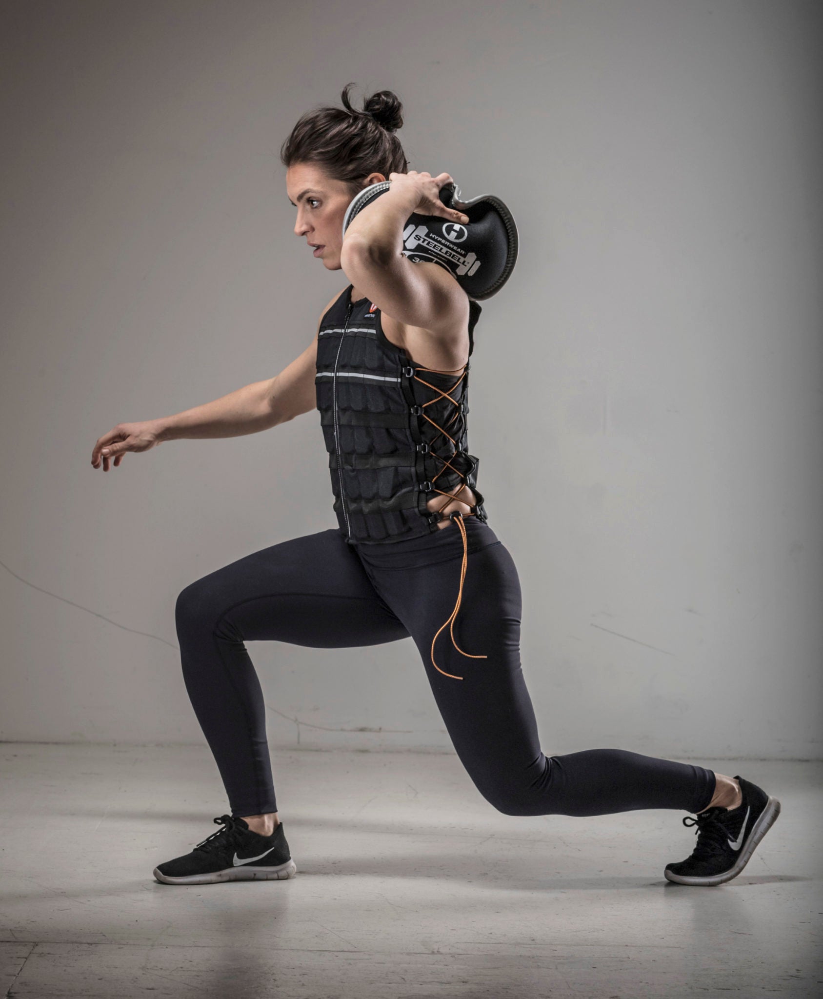 image of female fitness model doing a forward lunge with a SteelBell kettlebell alternative on one shoulder